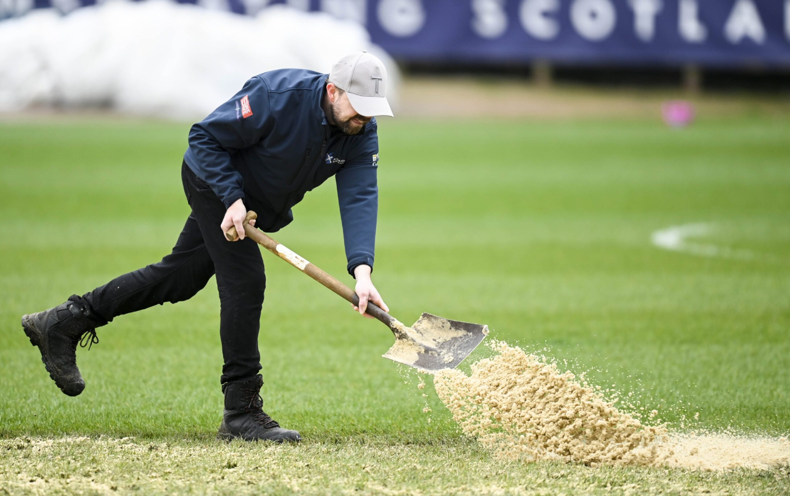 Ground staff work on the Dens pitch ahead of kick off. Image: SNS