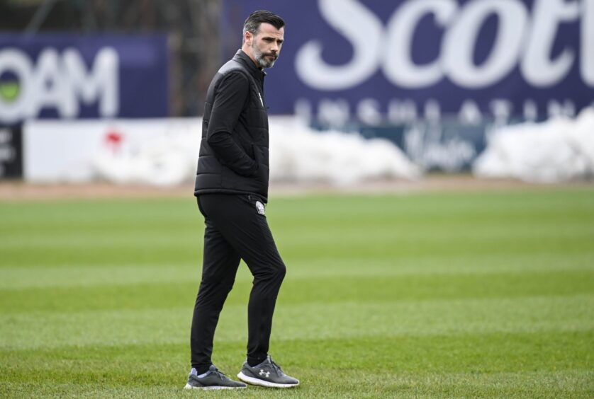 Motherwell manager Stuart Kettlewell inspects the Dens Park pitch. Image: SNS