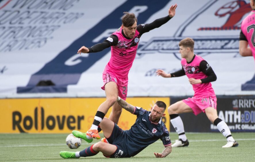 Raith Rovers attacker Dylan Easton lies on the ground after a challenge with an Ayr United opponent.