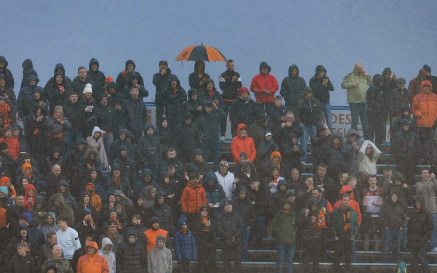 Dundee United fans brave the rain at Cappielow. 