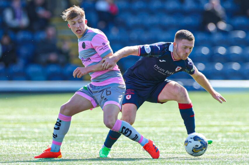 Raith Rovers striker Callum Smith crouches as he holds off Partick Thistle midfielder Ben Stanway.