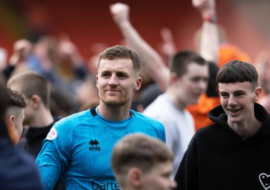 Jack Walton among jubilant Dundee United fans after winning the Championship title. Image: SNS
