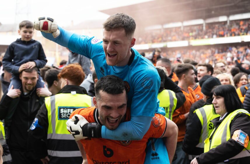Dundee United's Jack Walton, in blue, celebrates with Tony Watt as fans come on to the Tannadice pitch