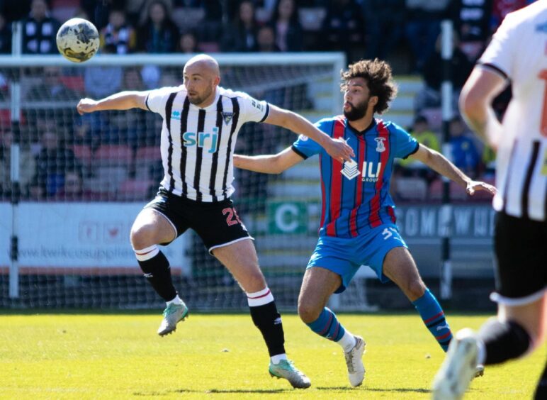 Dunfermline's on-loan St Johnstone striker Chris Kane holds off Inverness defender Remi Savage as he tries to tame a high ball.