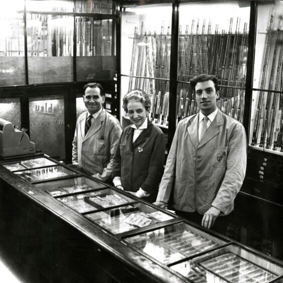 William O'Neil, Dr Evelyn Walker and Mr Johnston behind the counter in Gow's gun shop shop in 1965.