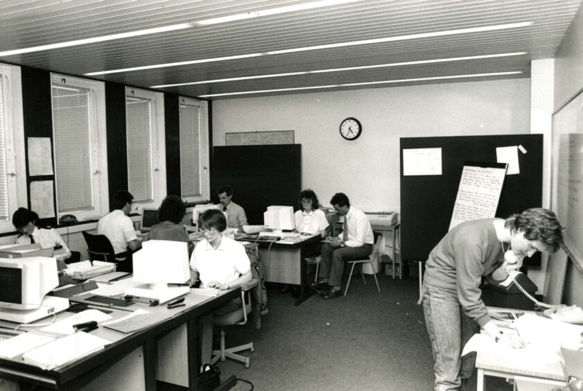 People at desks and answering phones in the incident room at Bell Street HQ 