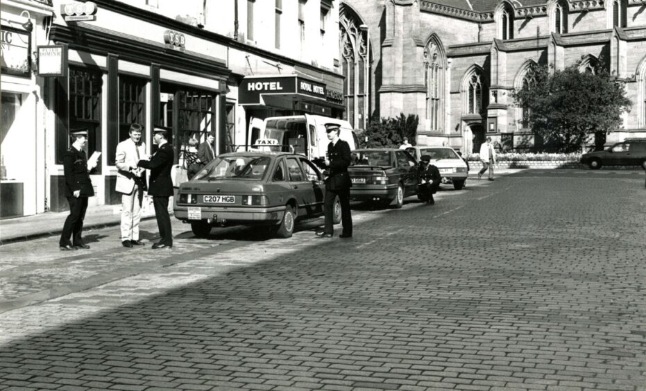 Police in Union Street interview passing car drivers after the Gow's gun shop murder