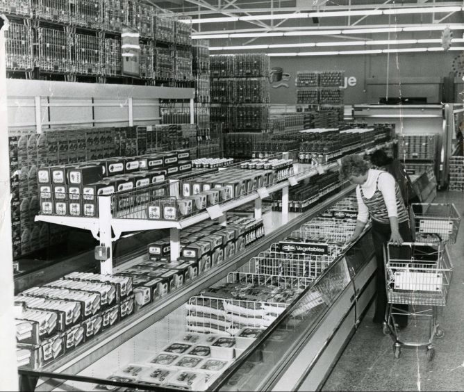 A woman browsing the frozen foods aisle in April 1977. 