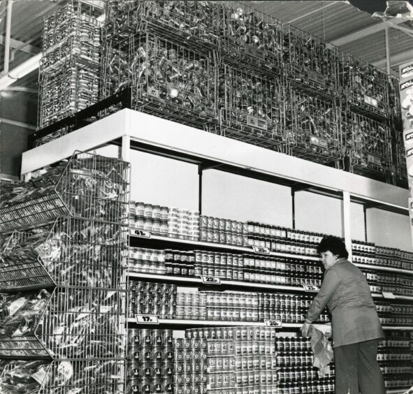 A worker in the aisle containing spreads and preserves. 