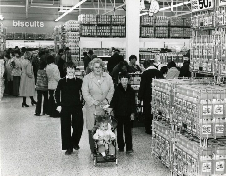 A mother shopping with her three children in the busy store. 