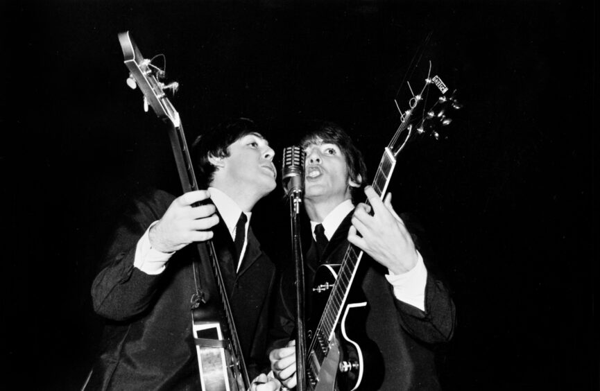 Paul McCartney and George Harrison on stage at the Caird Hall in Dundee on October 20 1964.