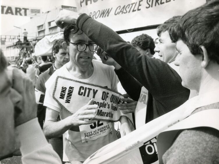 Don Macgregor is presented with his medal and sash for winning.