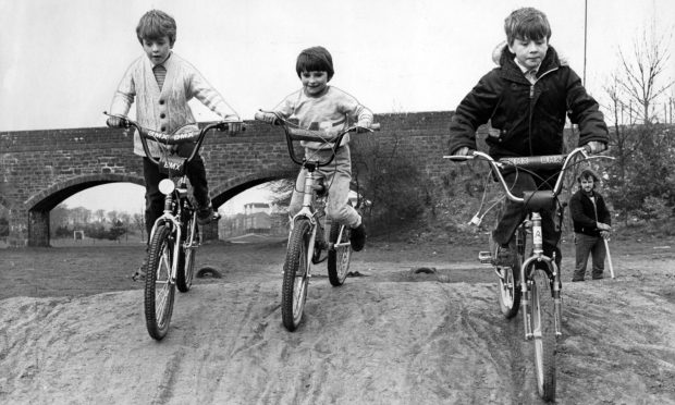 Three youngsters come over a rise on their bikes as they get to grips with the Finlathen track