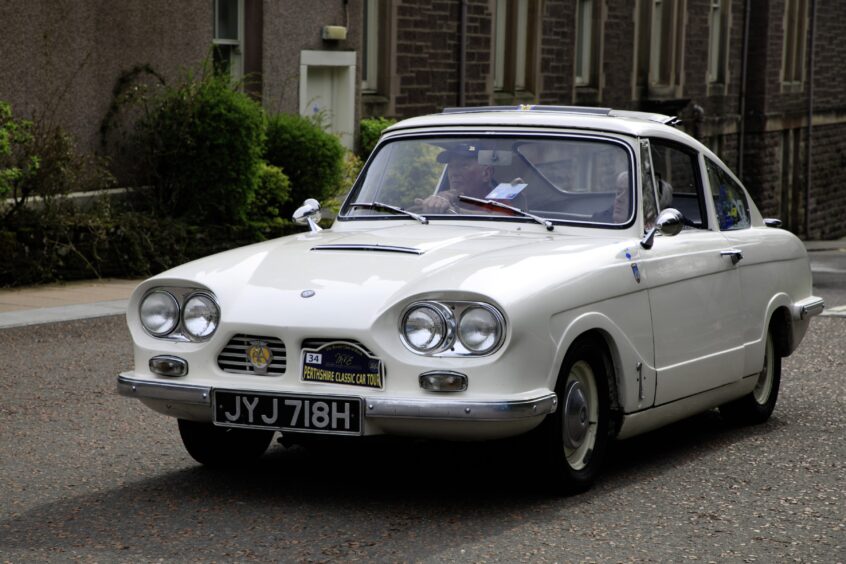 Small white 1969 Bond Equipe car driving up road to Crieff Hydro Hotel