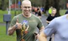 Steven McCready giving thumbs up gesture as he goes round parkrun course at Perth's North Inch with other runners