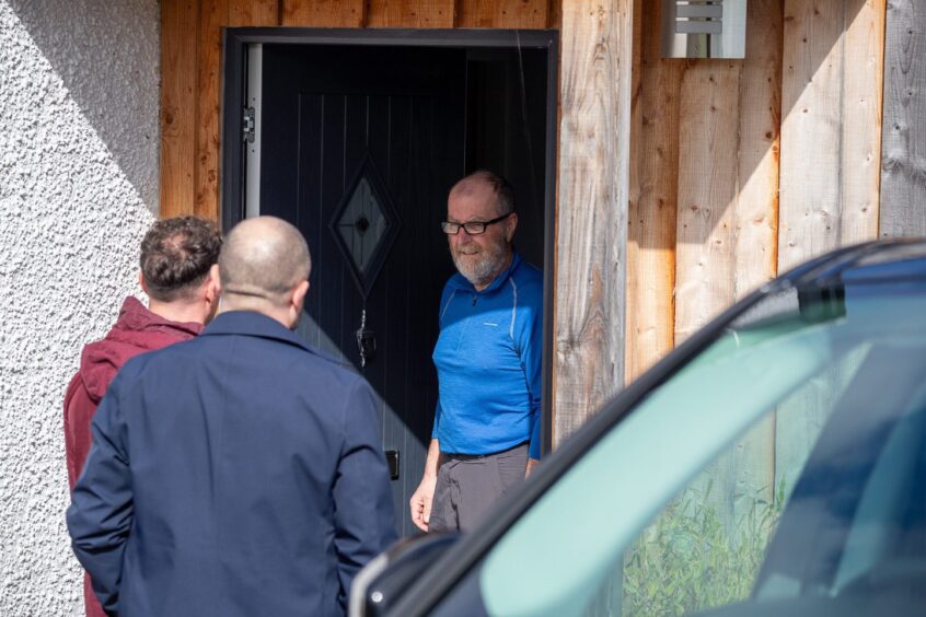 Police officers at door of a bearded man in Aberfeldy