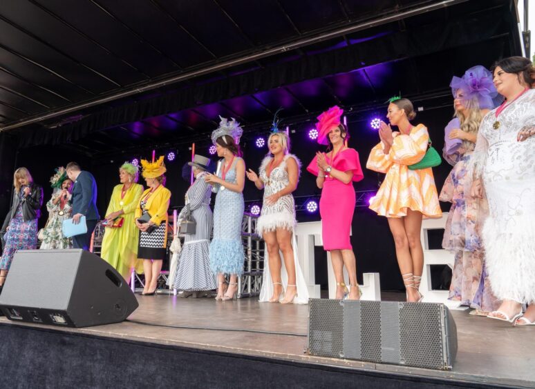ladies dressed to the nines compete in a fashion contest on stage