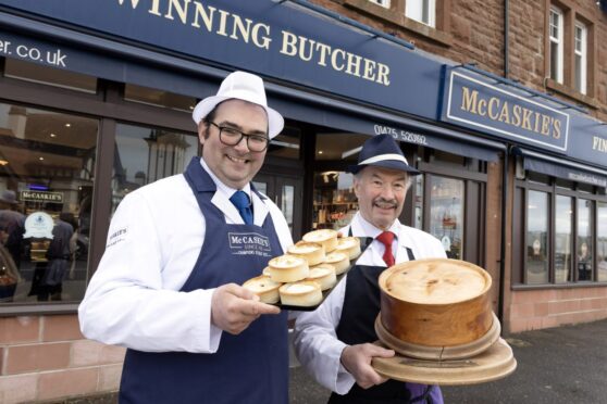 Nigel Ovens of McCaskie's (left) and Newtyle butcher Alan Pirie toast the deal. Image: Perthshire Picture Agency