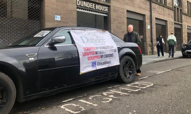 Hector McKay protesting outside Dundee House. Image: James Simpson/DC Thomson