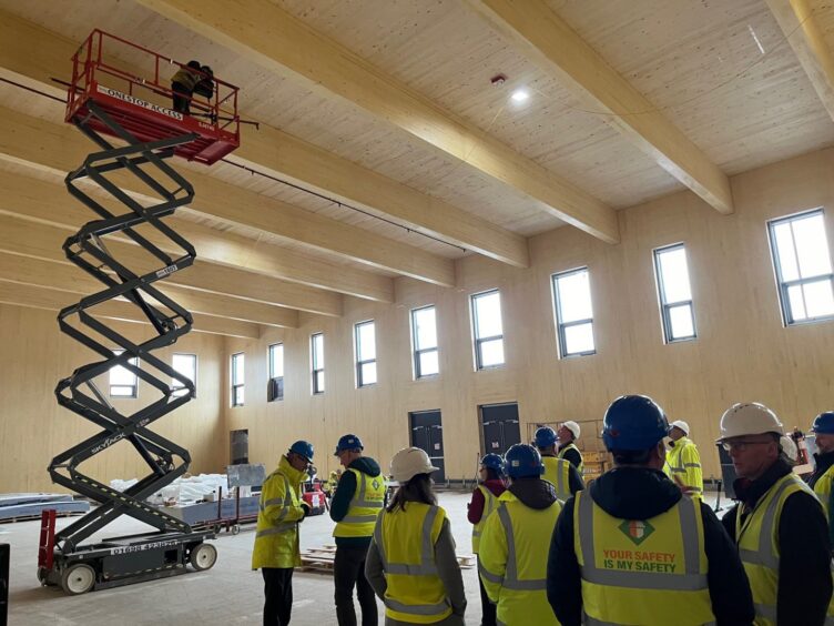 People in hard hats and hi vis jackets inside new Blairgowrie recreation centre