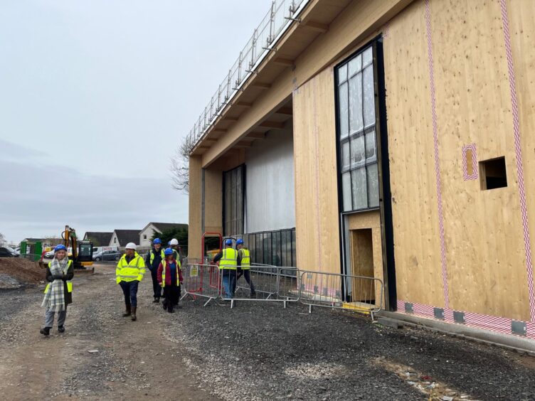 New Blairgowrie recreation centre exterior, with people in high vis and hard hats walking past what will be the entrance
