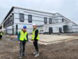 John Swinney and Stuart Jenkins from BAM in high-vis vests in front of new Blairgowrie recreation centre construction site