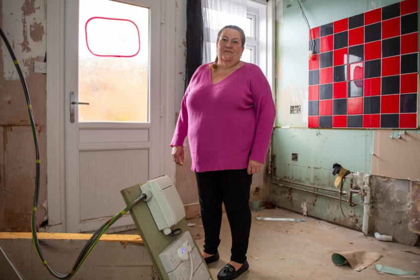 June Soutar's home in East Mill Road is still uninhabitable. She is standing in a gutted kitchen.