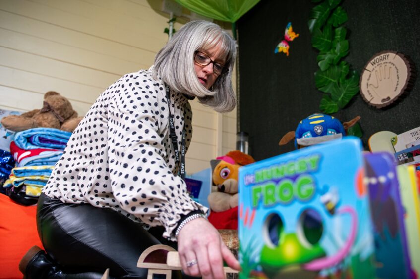 Image shows Gill Thomson at The Yard, Dundee. Gill is sorting some of the toys that children can play with at The Yard when they visit.