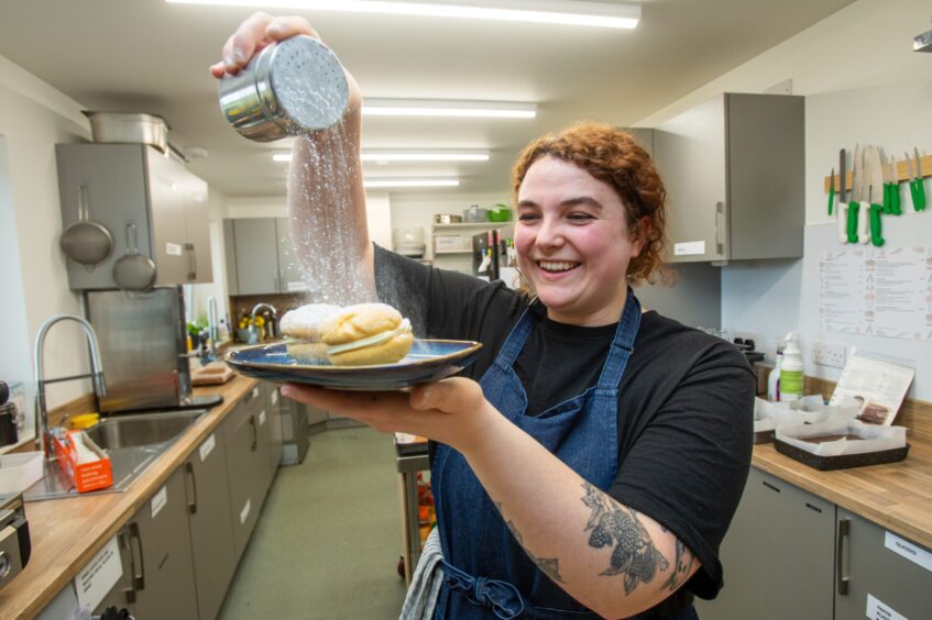 Chef Julia Burns-Cowie dusting some cakes with icing sugar at Braw Tea Cafe. 