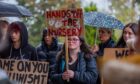 Parents holding placards protesting Perth college nursery closure plans