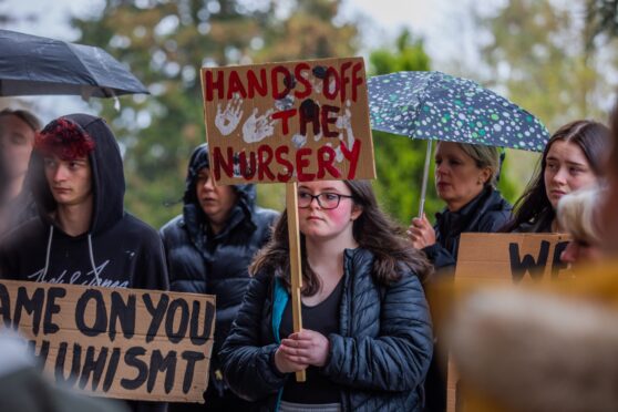 Parents holding placards protesting Perth college nursery closure plans