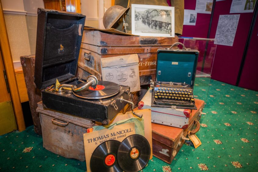Objects on display in Fisher's Hotel, including gramophone, soldier's helmet, suitcases and black and white photos