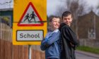 Ben and Charlie Lothian beside a school crossing sign.