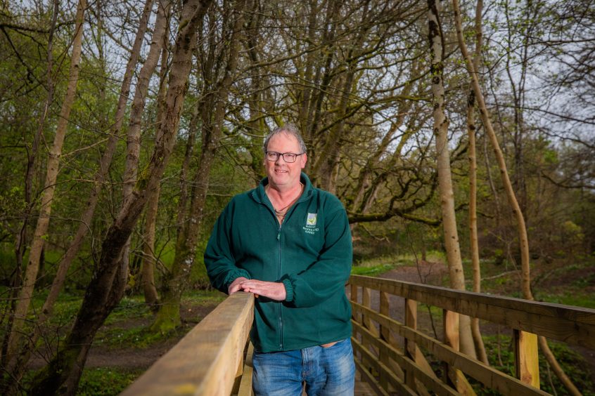 Victor Clements leaning on bridge in woodland