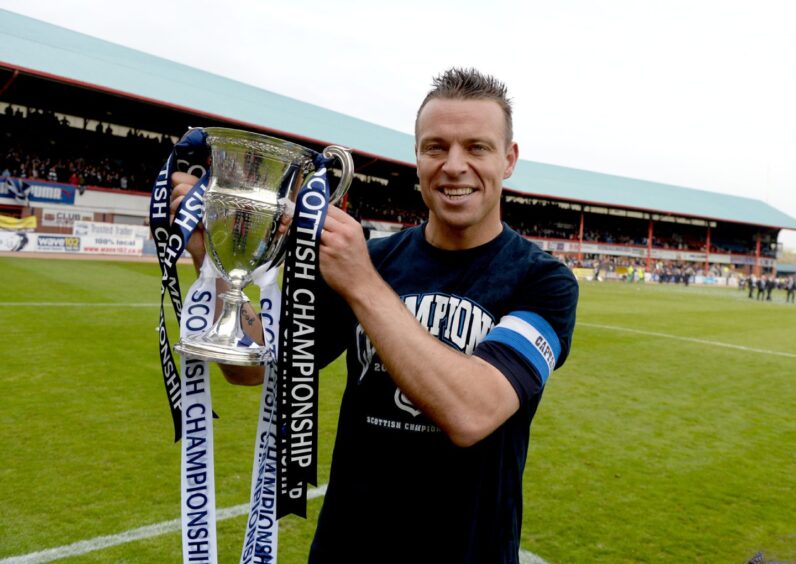Gavin Rae celebrates with the trophy on the Dens Park pitch