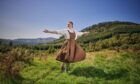 Actress dressed as Maria from Sound of Music in hills above Pitlochry Festival Theatre