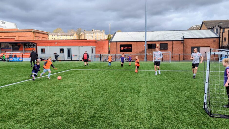 Sam McClelland and Liam Grimshaw playing alongside kids during the Dundee United Community Trust's Easter holiday camps