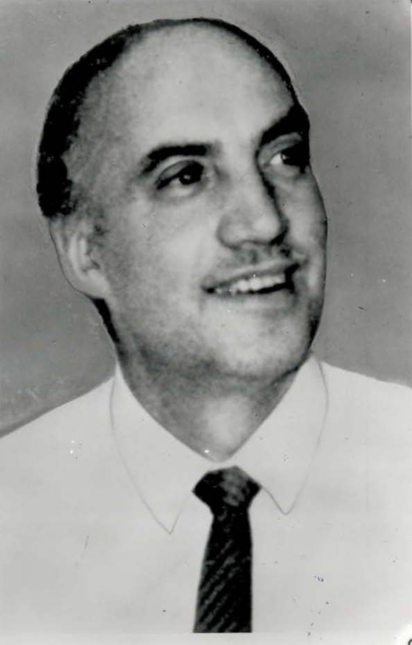 A smiling Gordon Johnston, manager of Gow's gun shop, wearing a shirt and tie