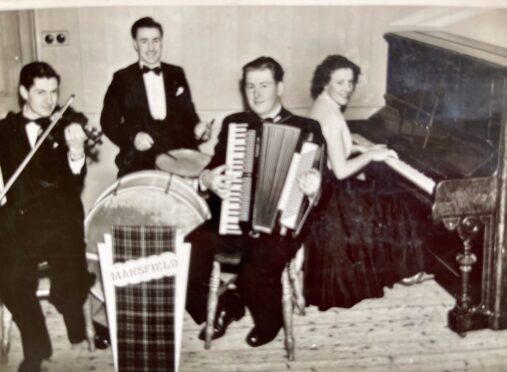 Joan Blue playing piano in black and white photo of Scottish country dance band quartet