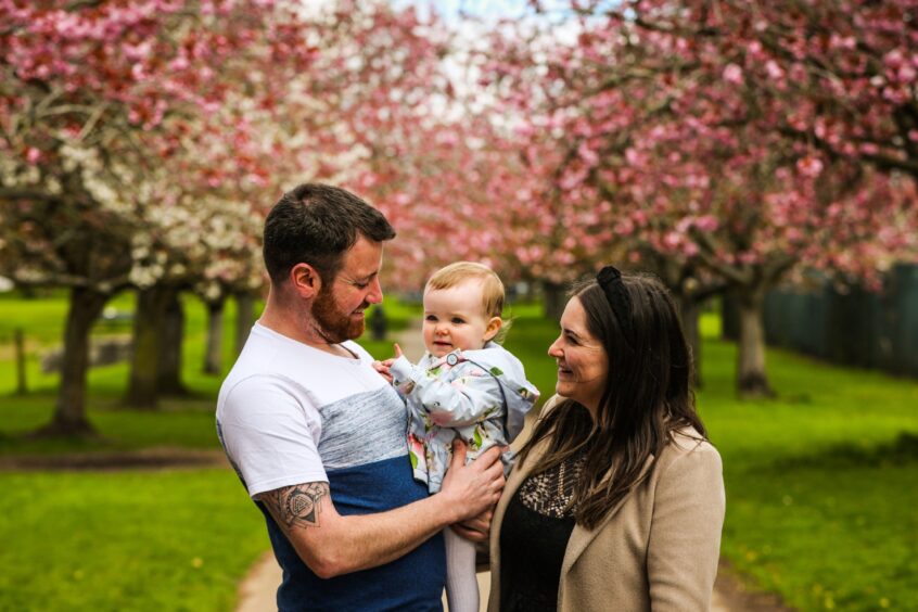 Fraser, Olivia, 1, and Fiona Anderson on a walk through the cherry blossoms in Dawson Park.