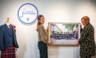 Hannah Cain of Strathmore Woollen Company and Rachel Jackson of Angus Alive hang a photo in the Piping Routes exhibition.