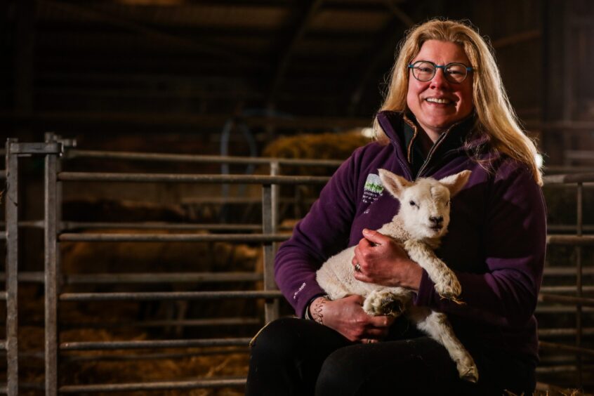 Farmer Louise Nicoll with one of her lambs.