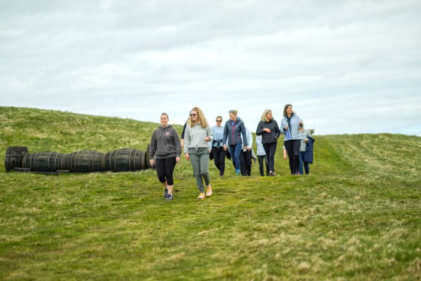 A group of women walk down a grassy slope, on Joanna's review of Lindores Fife.