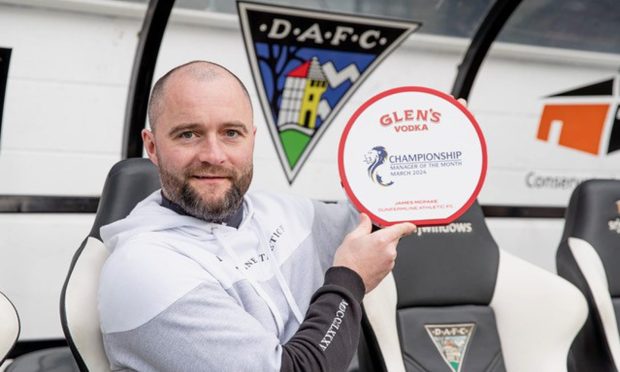 Dunfermline Athletic F.C. boss James McPake holds up the manager of the month trophy for March.