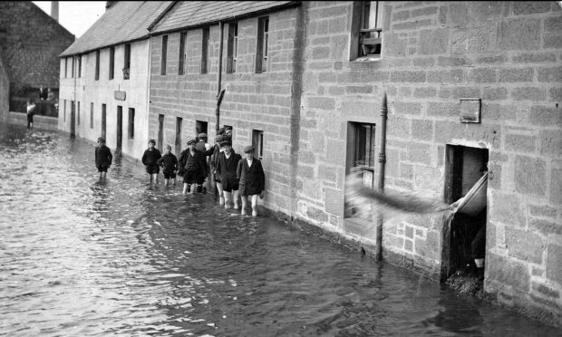 Children stranded in flood water in 1913. Image: DC Thomson.