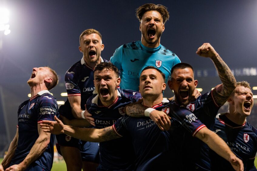 The Raith Rovers players surround Lewis Vaughan as they celebrate their penalty shoot-out victory over Partick Thistle.
