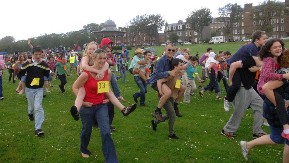 People take part in the Guinness World Record largest piggyback race in 2011. 