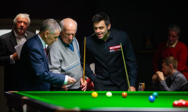 O'Sullivan and some local players gather round the snooker table during his time in Arbroath.