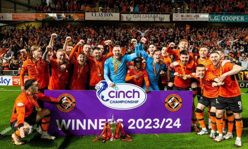 Dundee United players celebrate with the league trophy in front of a packed Eddie Thompson Stand.