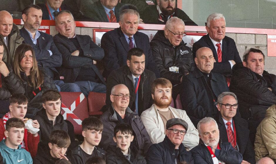 Raith Rovers manager Ian Murray sits in a crowded stand.